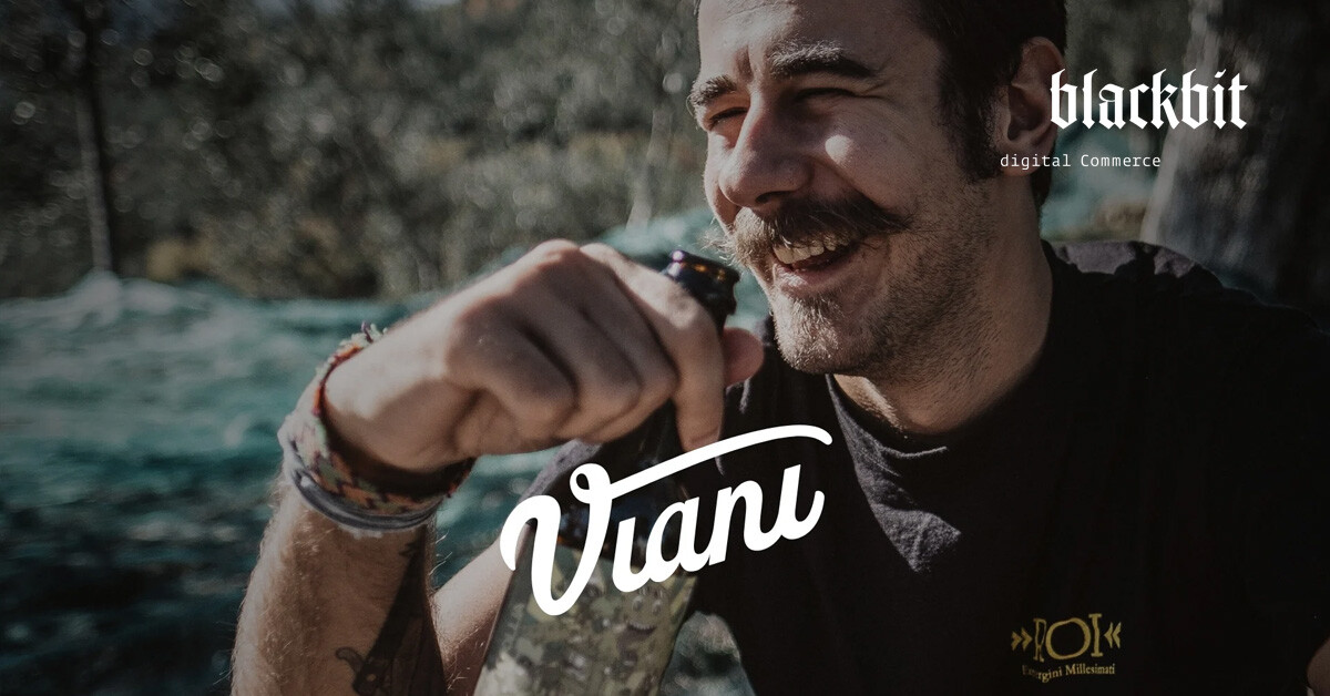 Lächelnder älterer Mann in der Natur mit Weinflasche in der Hand, Viani-Schriftzug im Vordergrund.