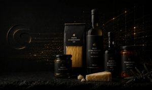 Hochwertiges Stillleben mit italienischen Feinkostprodukten (Olivenöl, Pasta, Pesto, Balsamico, getrocknete Tomaten und Käse) auf dunkler Oberfläche, ergänzt durch dezente goldene Datenfluss-Akzente und ein zurückhaltend geprägtes Shopware-Logo im Hintergrund.